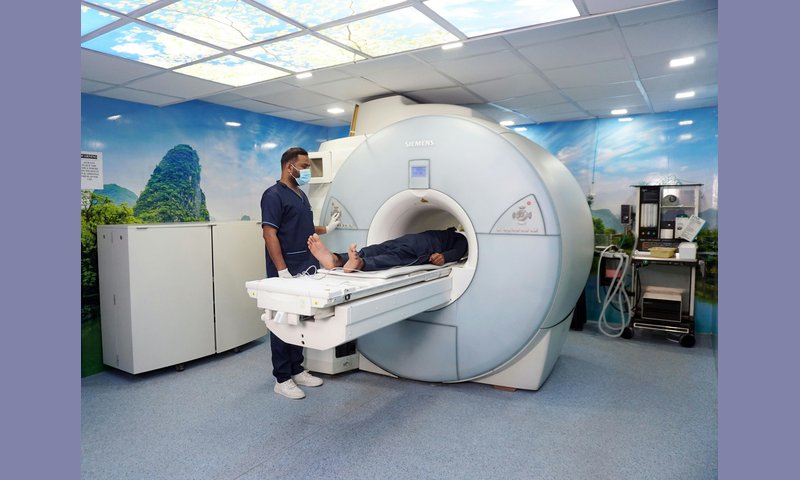 Machine de radiothérapie du cancer du sein — salle d'irradiation avec soignant et patient